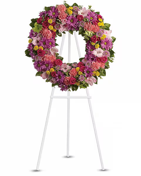 Colorful floral wreath on a white stand