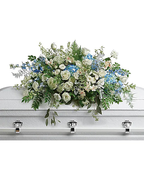 White coffin decorated with elegant flowers on white backdrop