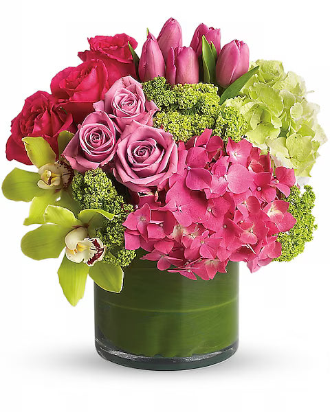 Pink and green flower bouquet in a clear vase.